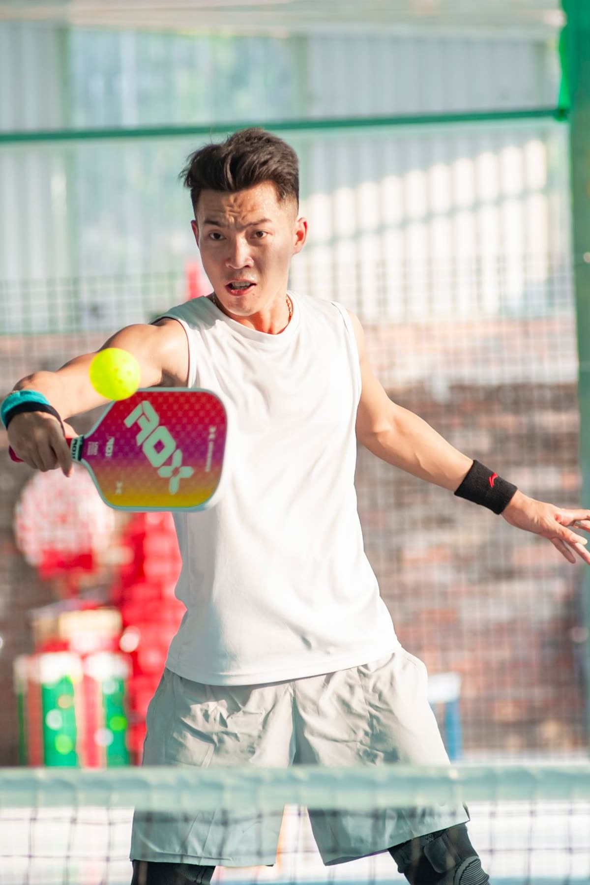 Player hitting a pickleball on an indoor court
